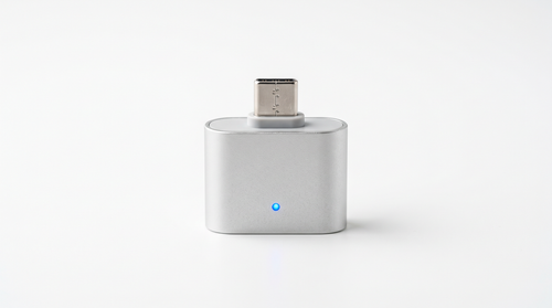 Auto-Disconnect Overcharge Protector — matte silver USB-C adapter with a blue charging status LED, studio shot
