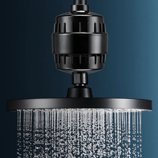Shower water filter fitted between the shower arm and a black rain shower head with water running